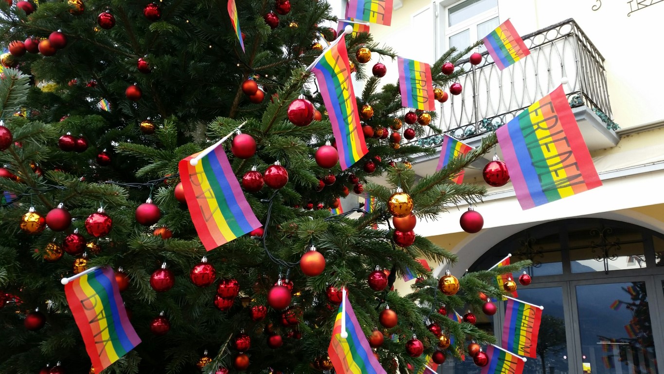 Regenbogenfahnen am Stab eingesetzt als Weihnachtsdekoration