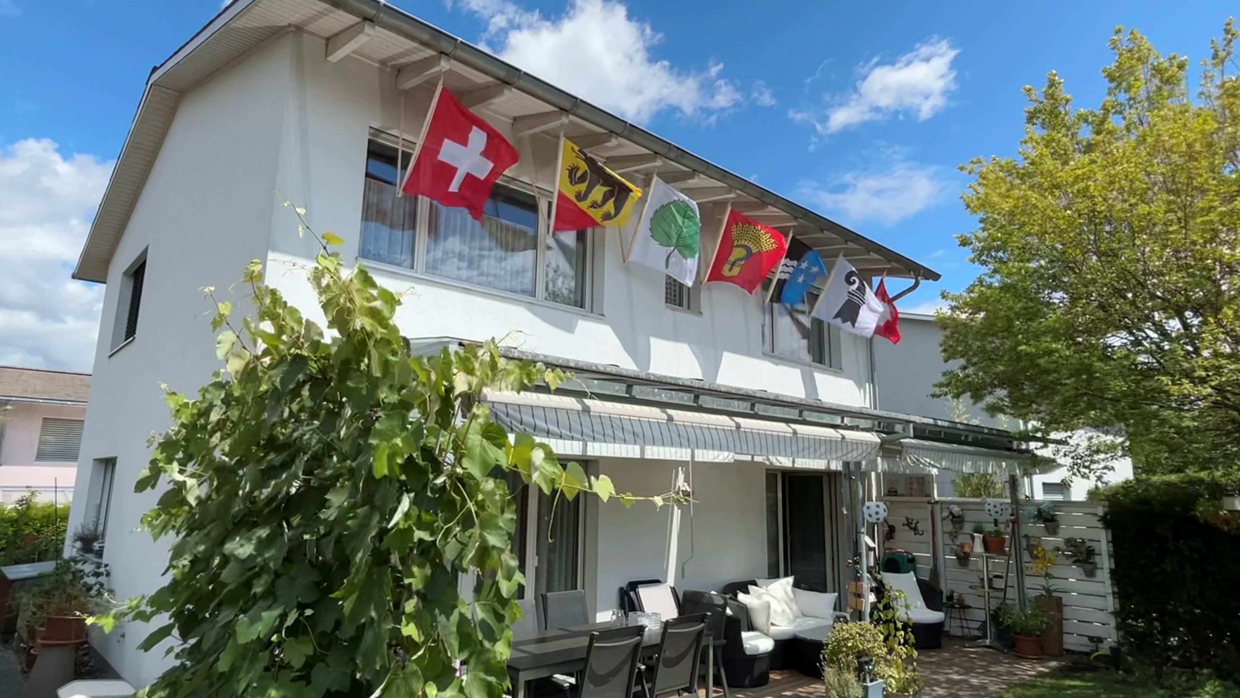 Haus mit verschiedenen heraldischen Fahnen.